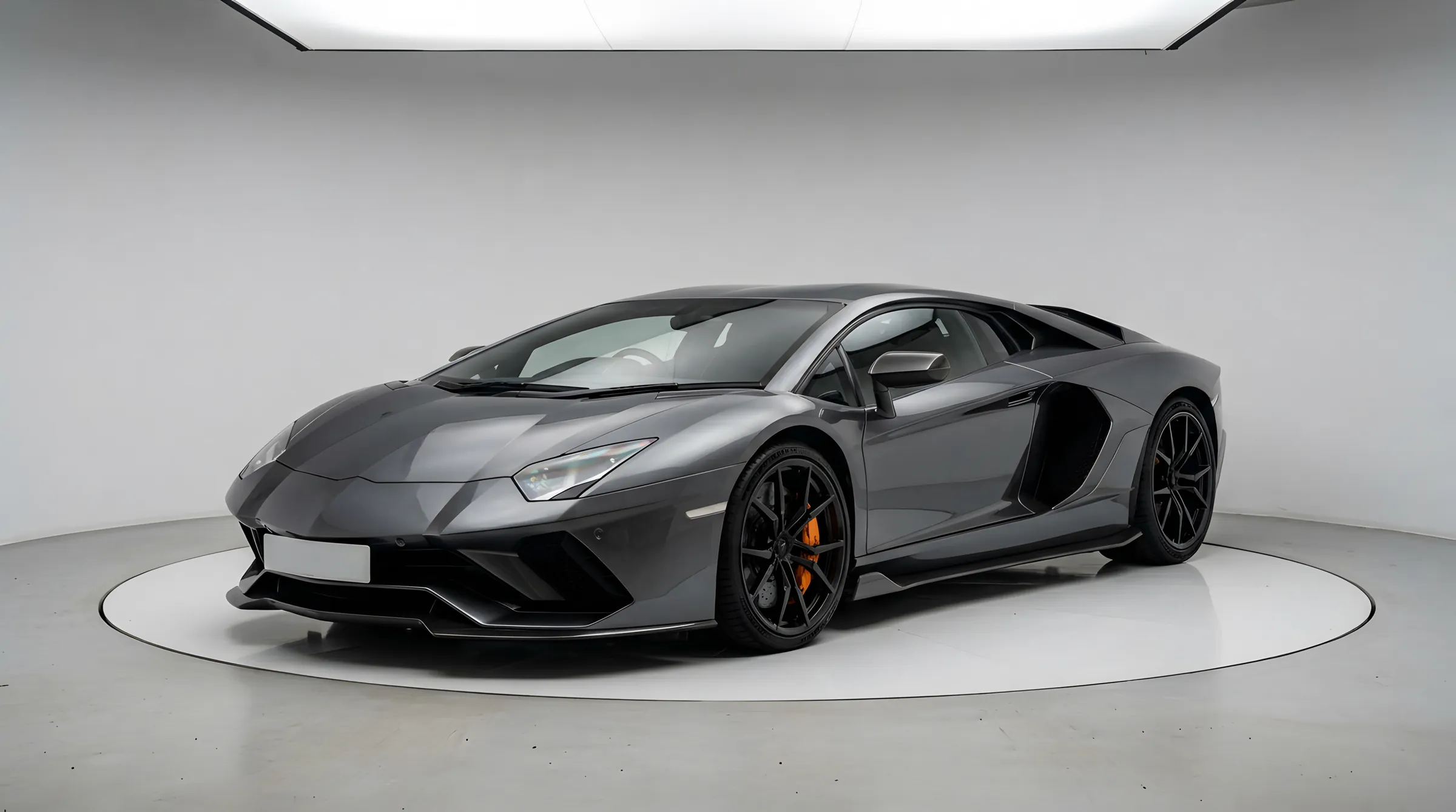 An unbadged dark grey supercar on a white studio turntable